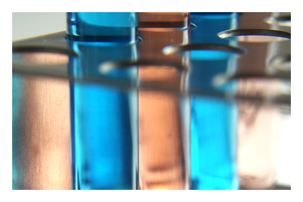 Two vials of blue liquid in vial rack