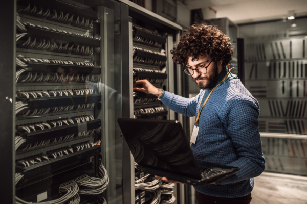 A man with laptop checking the server in server room